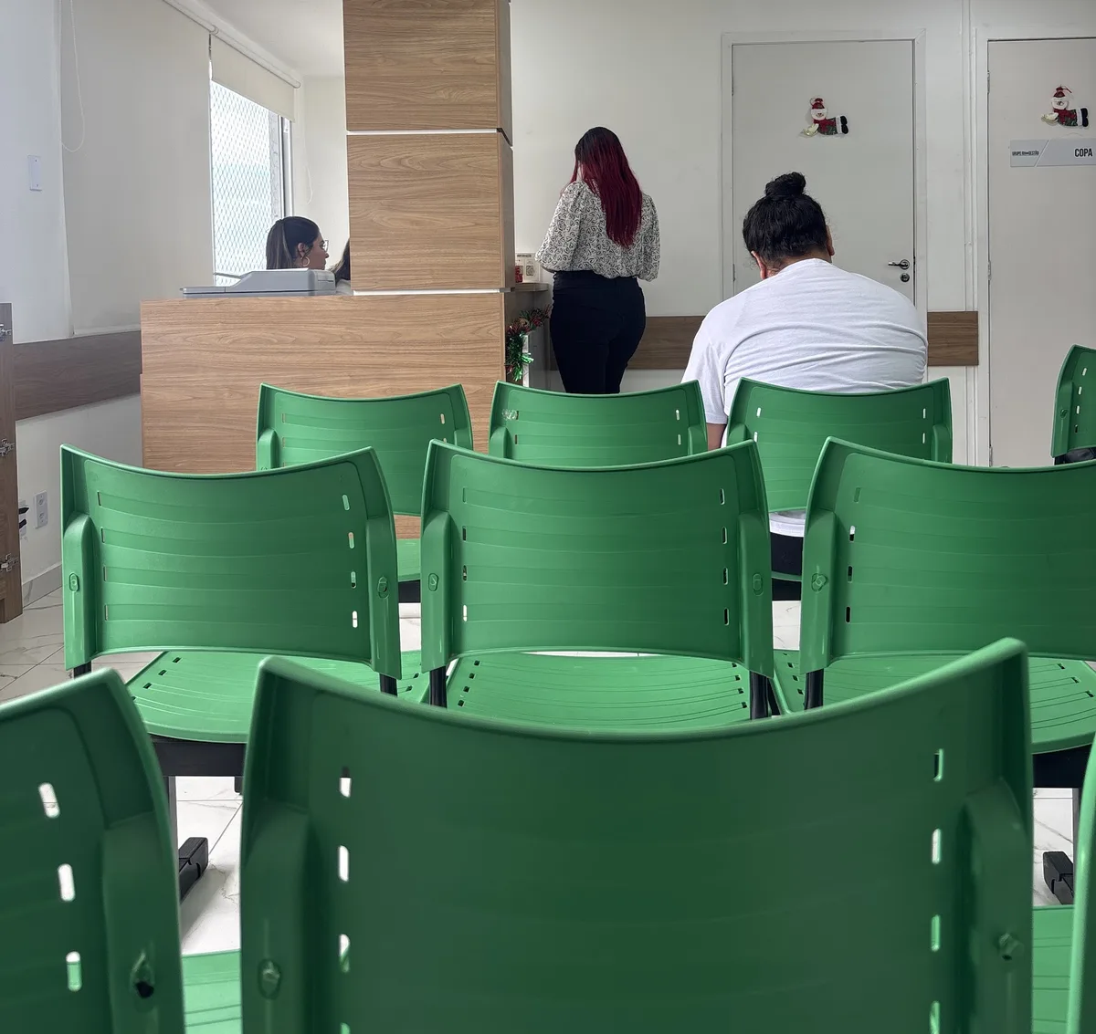 Sala de espera do Grupo RH+, com cadeiras verdes e recepção